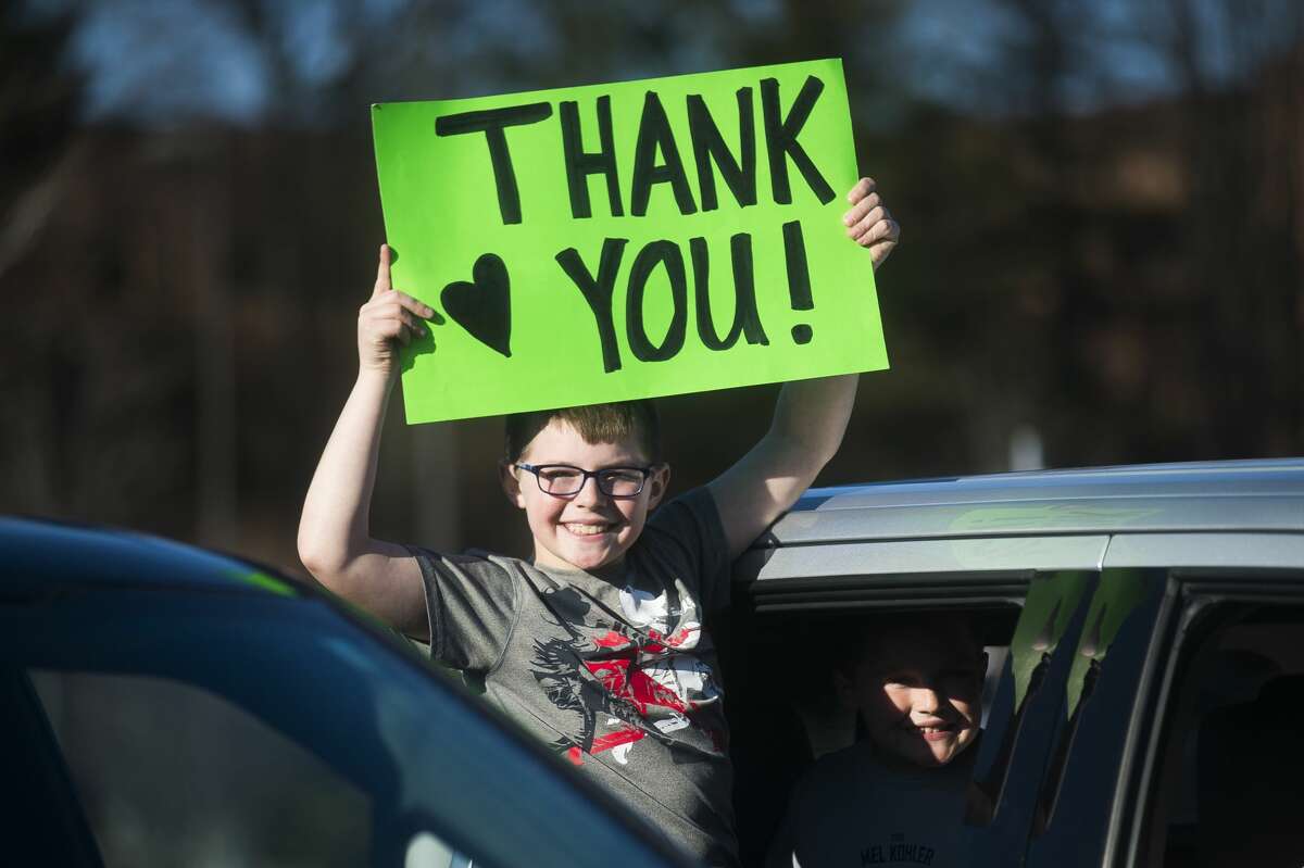 Midland residents gather in a parking lot outside of MidMichigan Medical Center-Midland to show their appreciation for healthcare workers by holding signs, cheering and honking their horns Thursday, April 2, 2020. (Katy Kildee/kkildee@mdn.net)