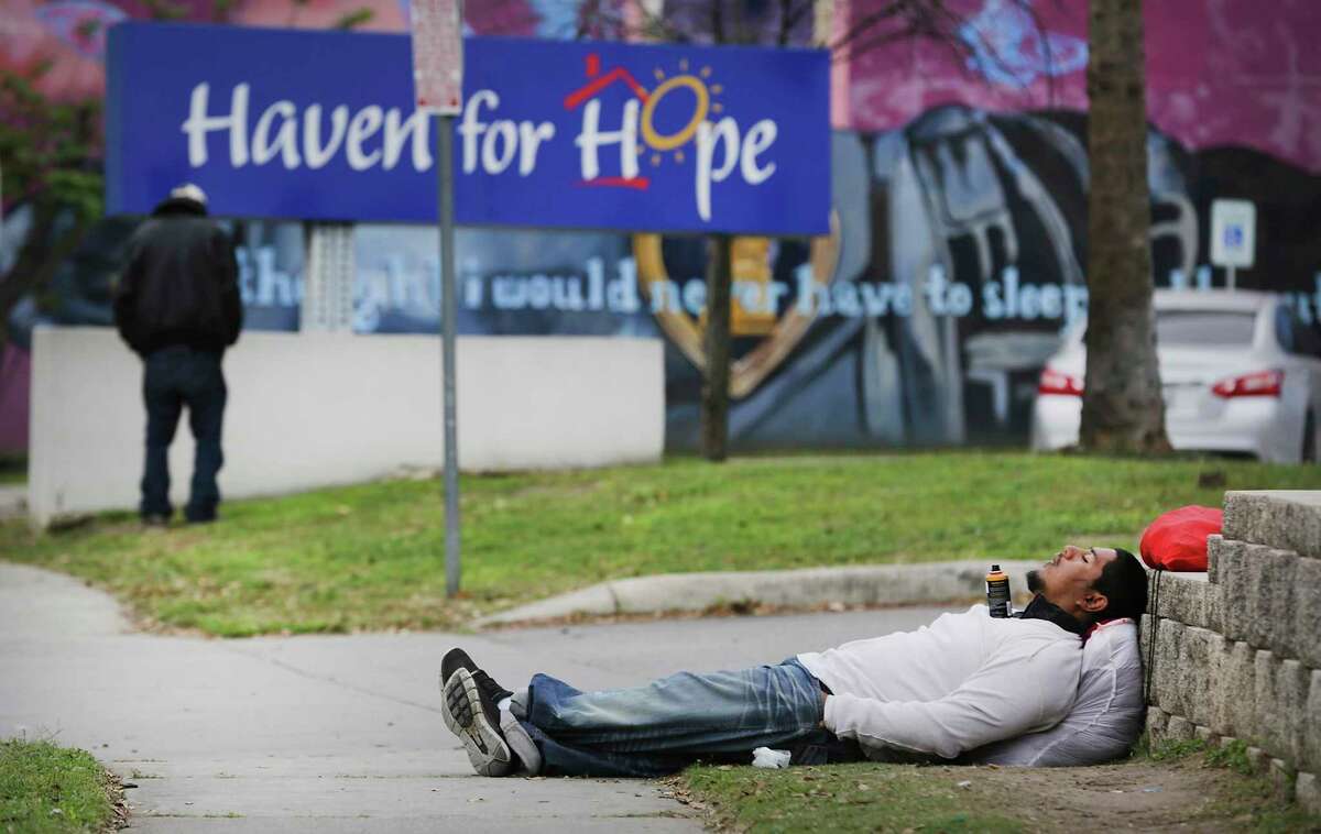 A homeless man sleeps on the sidewalk Thursday next to Haven for Hope, which has stopped taking in new people looking for shelter. The city will now house nearly 80 homeless people at risk of serious consequences if they were to contract the deadly virus in a hotel that closed because tourists were no longer coming to San Antonio because of the state and national coronavirus restrictions.