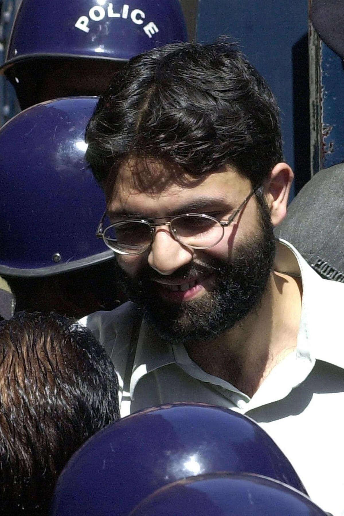 (FILES) In this file taken on March 29, 2002, Sheikh Omar, chief suspect of slain US journalist Daniel Pearl smiles while talking to Pakistani police officials in Karachi. - A Pakistani court on April 2, 2020 overturned the death sentence for British-born militant Ahmed Omar Saeed Sheikh, who had been convicted over the 2002 killing of American journalist Daniel Pearl. (Photo by Aamir QURESHI / AFP) (Photo by AAMIR QURESHI/AFP via Getty Images)