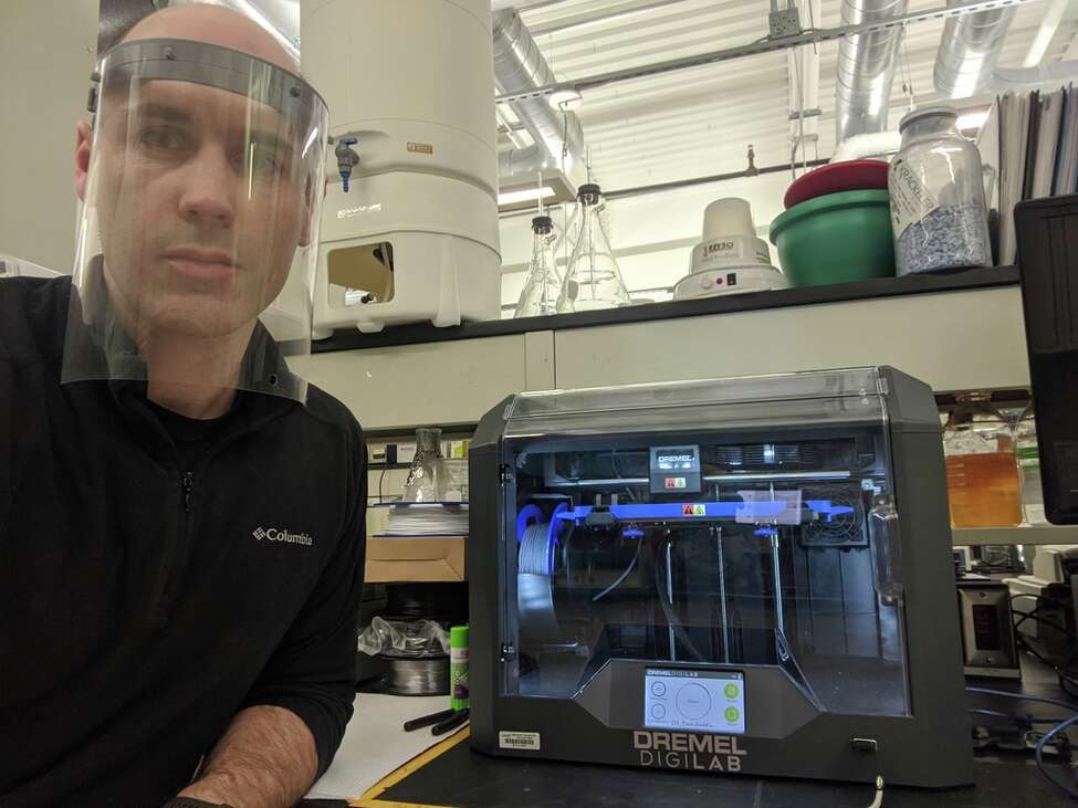 SUNY Poly nanobioscience professor Nate Cady making face mask shields with a 3-D printer at the school's Albany campus.