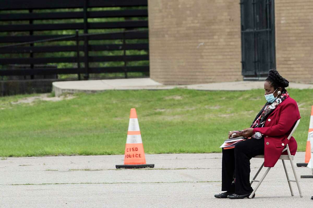 Rep. Sheila Jackson Lee, D-Texas, sits alone in the parking lot at Forest Brook Middle School working on her phone at a free coronavirus testing site on Thursday, April 2, 2020 in Houston.