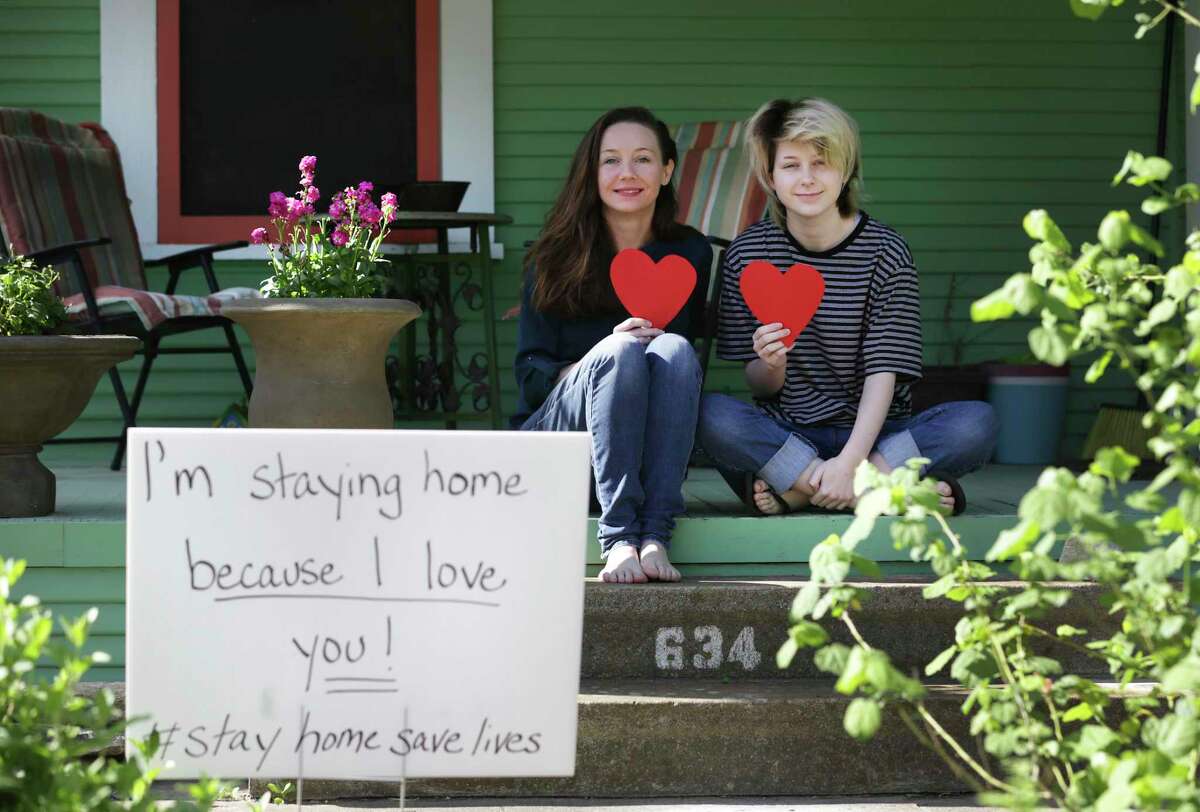 Christina Wright, left, President of the Alta Vista Neighborhood Association, and her daughter Neveah Crump, 15, have placed stuffed animals in a window and happy message signs in the yard.