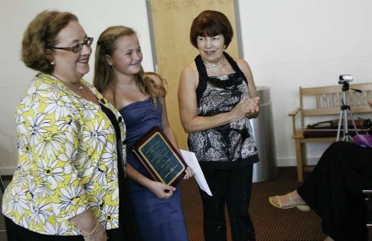 Elissa Getto, left, executive director of the Stamford Center For the Arts, and Asya Meshberg, right, artist director of the Chamber Music Institute for Young Musicians, present a scholarship and plaque to Anna Leunis, center, age 14, on Sunday, August 8, 2010. The scholarship is given on behalf of the SCA to help students pursue their musical talents.