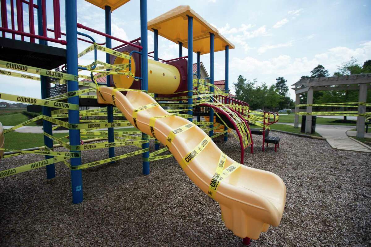 A playground is covered on caution tape, to discourage people from playing there due to coronavirus, in the Legends Trace subdivision on Sunday, March 29, 2020 in Spring.