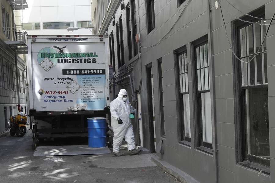 A worker in a haz-mat suit walks to an entrance to the Abigail Hotel in San Francisco, Thursday, April 2, 2020. Since the beginning of an international pandemic, officials in California have said one population is particularly vulnerable to contracting the coronavirus and spreading it to others: the homeless. The Abigail Hotel is one of several private hotels San Francisco has contracted with to take vulnerable people who show symptoms or are awaiting test results for coronavirus.