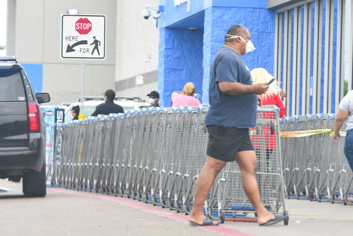 Shoppers wear face masks as part of a new city mandate to help reduce the spread of coronavirus COVID-19, Thursday, Apr. 2, 2020, at Wal-Mart.