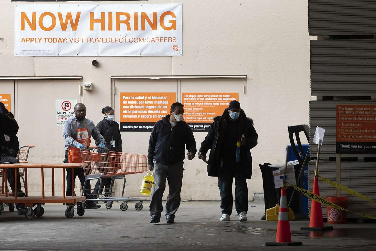 Home Depot customers carry their purchases as they leave the store, Friday, April 3, 2020 during the coronavirus pandemic in New York. (AP Photo/Mark Lennihan)