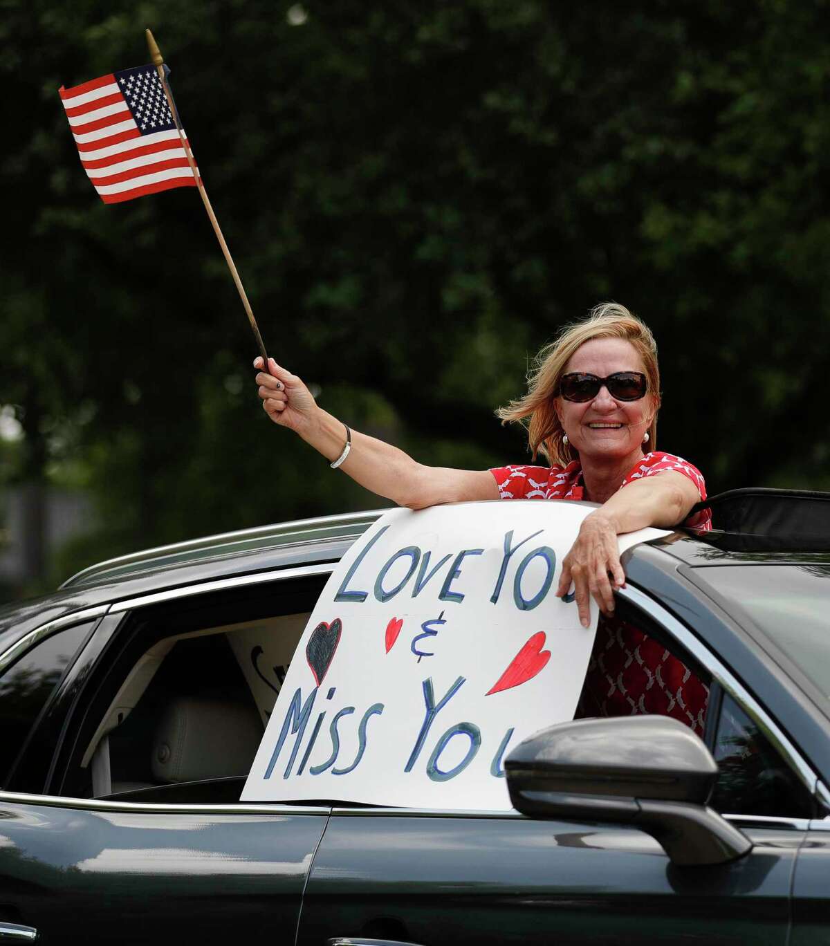 Cars pass by residents of the Carriage Inn Conroe assisted living facility as they take in a parade from friends, family and other community members, Friday, April 3, 2020, in Conroe.
