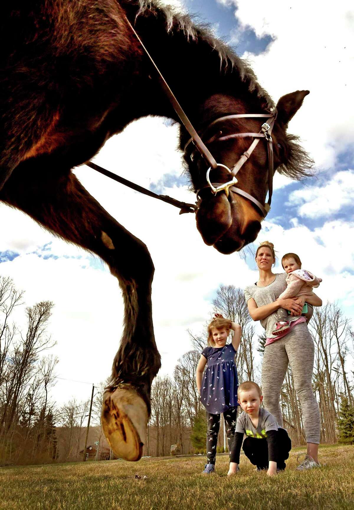 Cory Sells of Woodbridge using her Paso Fino breed horse Torpedo, 19, show's of his unique gait to Alissa Hill of Bethany and her children Madison, 1, Bradford, 3, and Mackenzie, 5. Sells, using Torpedo as a therapy horse, ride saround the Bear Hill Road area in Bethany twice a week, using social distancing, visiting neighborhood children and their parents staying in their homes during the coronavirus pandemic.