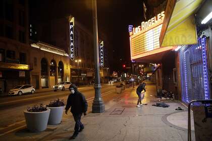 A masked pedestrian walks along Broadway Avenue in Los Angeles in April. Los Angeles Mayor Eric Garcetti has recommended that the city's 4 million people wear masks when going outside amid the spreading coronavirus.