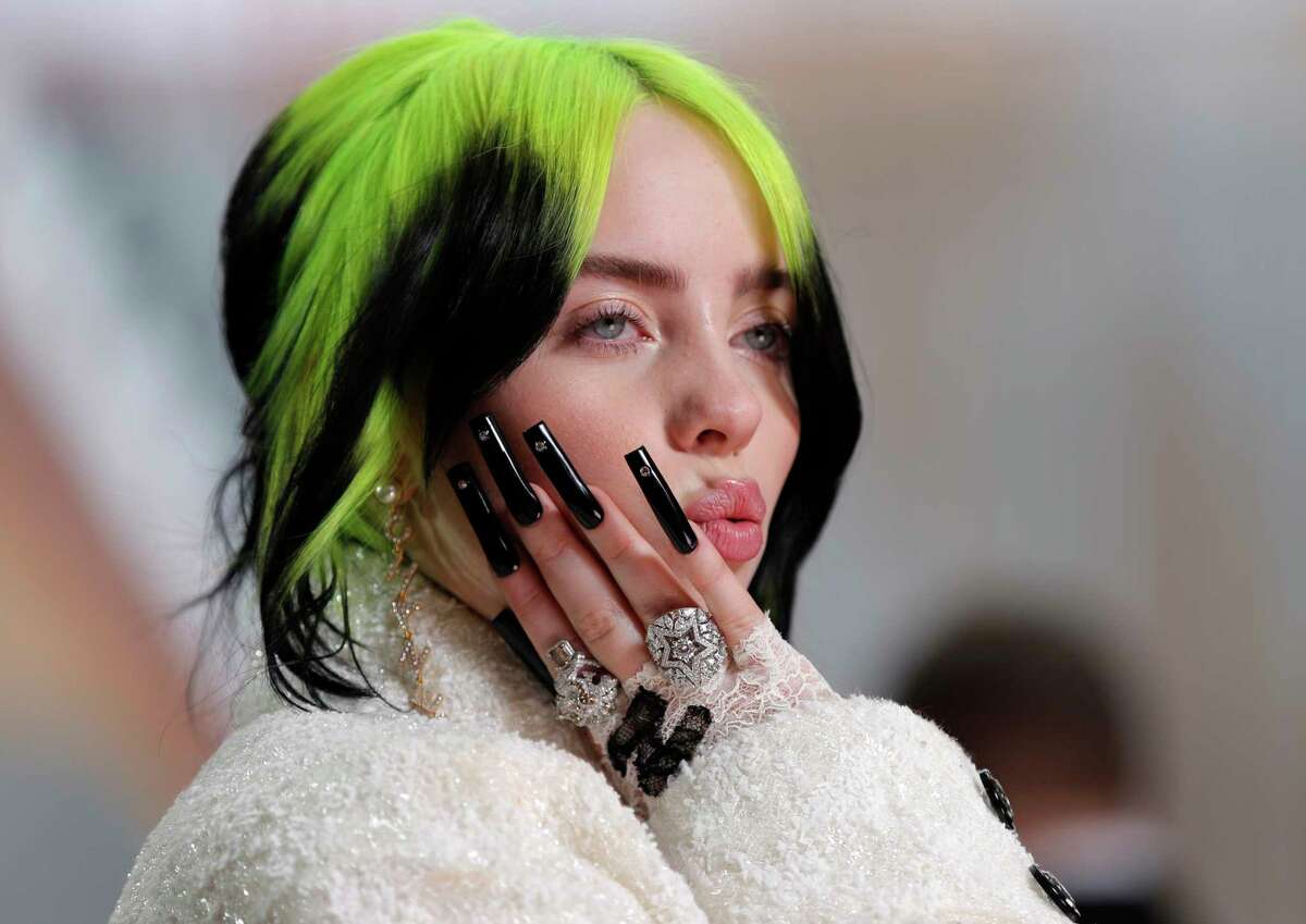 FILE - In this Feb. 9, 2020 file photo, singer Billie Eilish arrives at the Oscars in Los Angeles. The Elton John-led starry benefit concert that featured Eilish, Mariah Carey and Alicia Keys on Sunday has raised nearly $8 million to battle the coronavirus. The musicians performed from their homes for the hour-long event that aired on Fox and iHeartMedia radio stations. Fox will re-broadcast the concert on Monday, April 6. (AP Photo/John Locher, File)