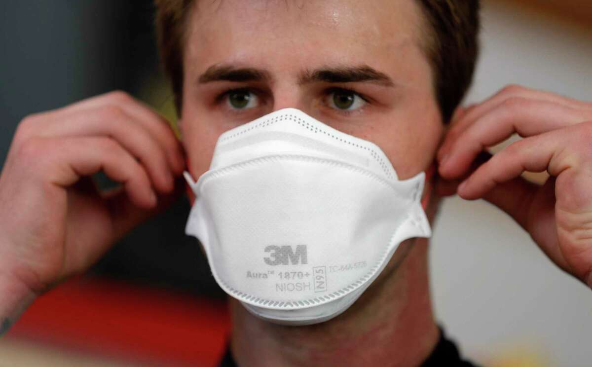 Conroe firefighter Tyler Wagner checks the fit of his newly issued 3M N95 mask, Tuesday, March 31, 2020, in Conroe.