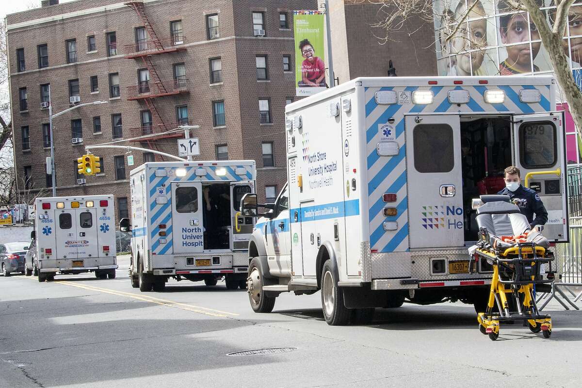 Ambulances line the street outside Elmhurst Hospital Center, Saturday, April 4, 2020 in the Queens borough of New York. The new coronavirus causes mild or moderate symptoms for most people, but for some, especially older adults and people with existing health problems, it can cause more severe illness or death. (AP Photo/Mary Altaffer)