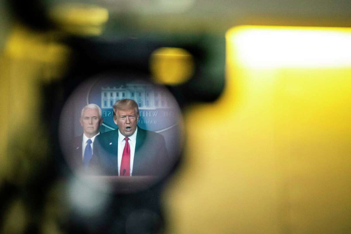 President Trump, reflected in a television camera, speaks with his coronavirus task force at a White House briefing on March 18., 2020.