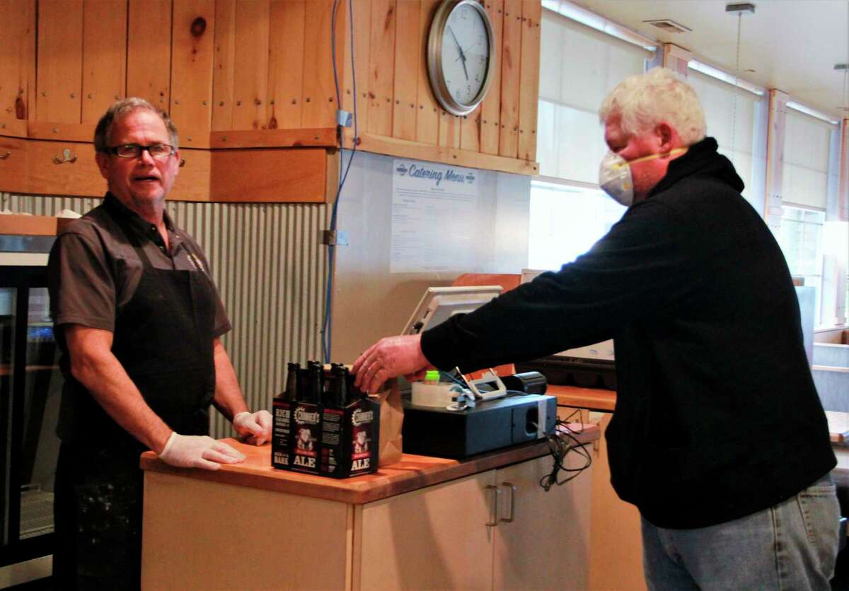 Crankers owner Jim Crank hands Stanwood resident Jim Becker his carry out order. Crankers is one of several businesses currently offering carry out orders. However, other businesses such as Bernie's Place and The Pie Hole have chosen to temporarily close their doors in light of recent coronavirus concerns. (Pioneer photos/Alicia Jaimes)