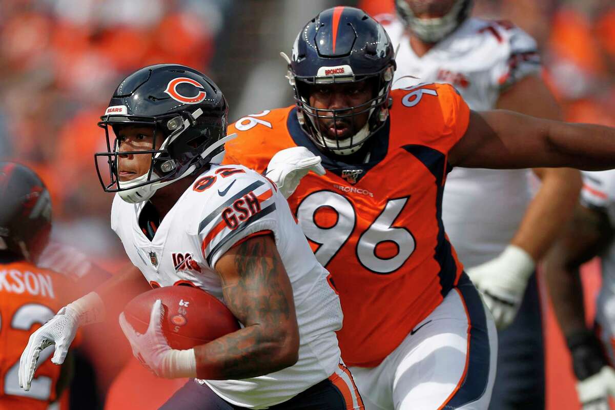 FILE - In this Sept. 15, 2019, file photo, Chicago Bears running back David Montgomery (32) is pursued by Denver Broncos defensive tackle Shelby Harris (96) during the first half of an NFL football game in Denver. The coronavirus pandemic has forced NFL teams to make free agent decisions without the benefit of meeting players face to face. That suppressed the market for plenty of lower-tier free agents such as Harris who signed a one-year deal for $2.5 million with a chance to earn another $750,000. (AP Photo/David Zalubowski, File)