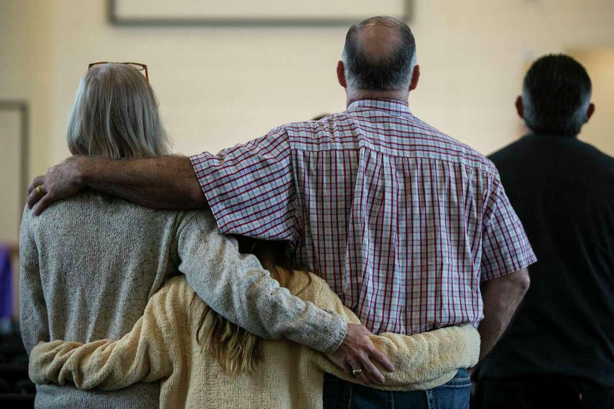 A holds onto each other during the worship portion of Sunday services at First Baptist Church in Sutherland Springs, Texas, April 5, 2020. First Baptist Church services have continued, despite CDC guidance to not have more than 10 people in a gathering, but congregants have the option to live stream the service from home. Pastor Frank Pomeroy said if the government forced the church to close its physical doors, he would file a constitutional lawsuit.