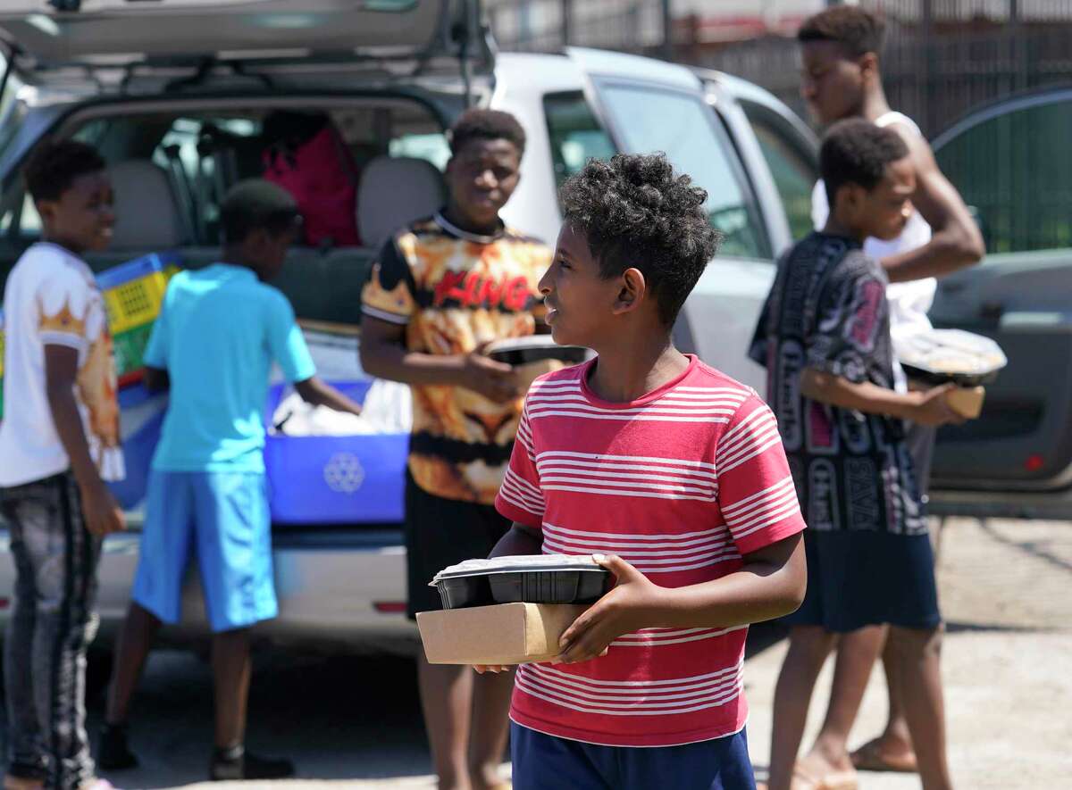 A group of boys at a Gulfton area apartment complex receive food from reVision Thursday, March 26, 2020.