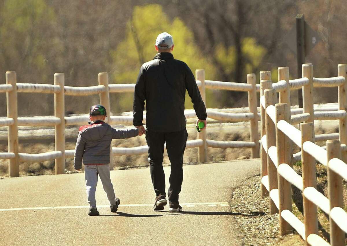 Walkers enjoy the sunny weather on the Derby Greenway section of the Naugatuck River Greenway in Derby, Conn. on Monday, April 6, 2020. The Ansonia section of the Greenway, called the Ansonia Riverwalk, has been closed due to social distancing concerns during the coronavirus pandemic.