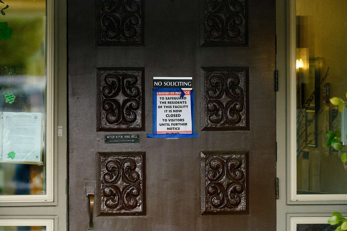 A sign hangs on the door at Orinda Care Center, where nearly 50 residents and staff members have tested positive for coronavirus, on Monday, April 6, 2020, in Orinda, Calif.