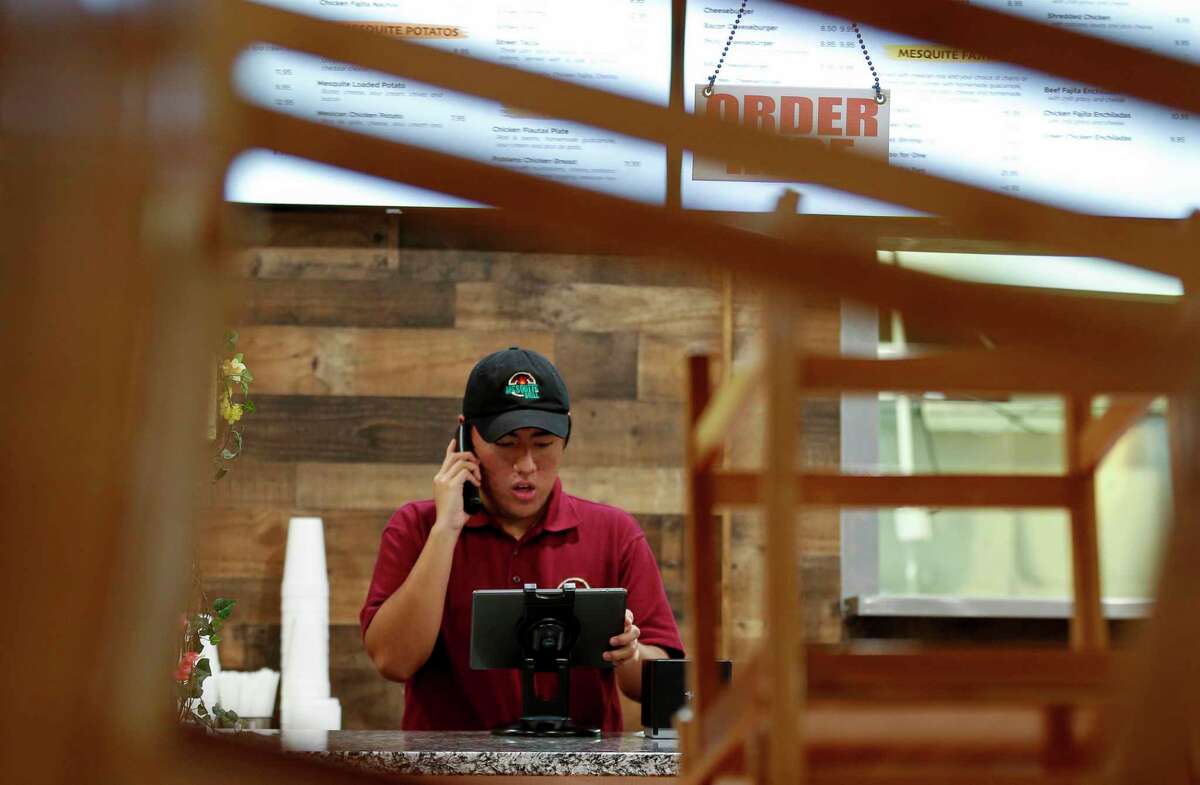 Alex Miranda takes a customer's to-go food order over the telephone inside The Mesquite Grill on Monday, April 6, 2020, in Houston. On Tuesday, Harris County Commissioners Court is working to approve a $10 million small business loan fund to help business hurt by the COVID-19 pandemic. The restaurant opened February 29 of this year, a week and a half later they had to closed the dinning room and only take to-go orders due to the pandemic.
