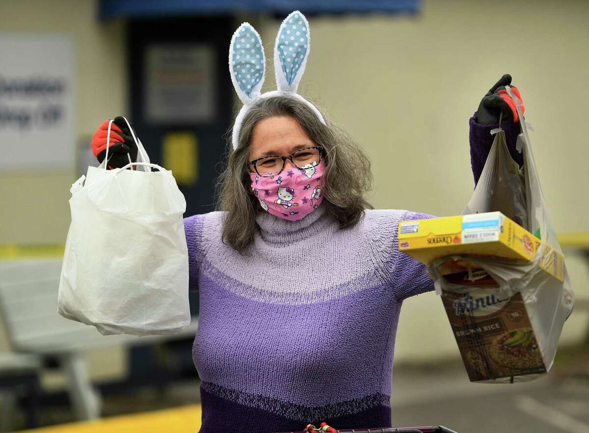 Decked out in festive Easter Bunny ears, Remy Kocurek, director of St. Vincent DePaul of the Valley, collects food donations at the food pantry at 237 Roosevelt Drive in Derby, Conn. on Sunday, April 5, 2020. The pantry has been accepting new clients in the wake of the coronavirus pandemic.