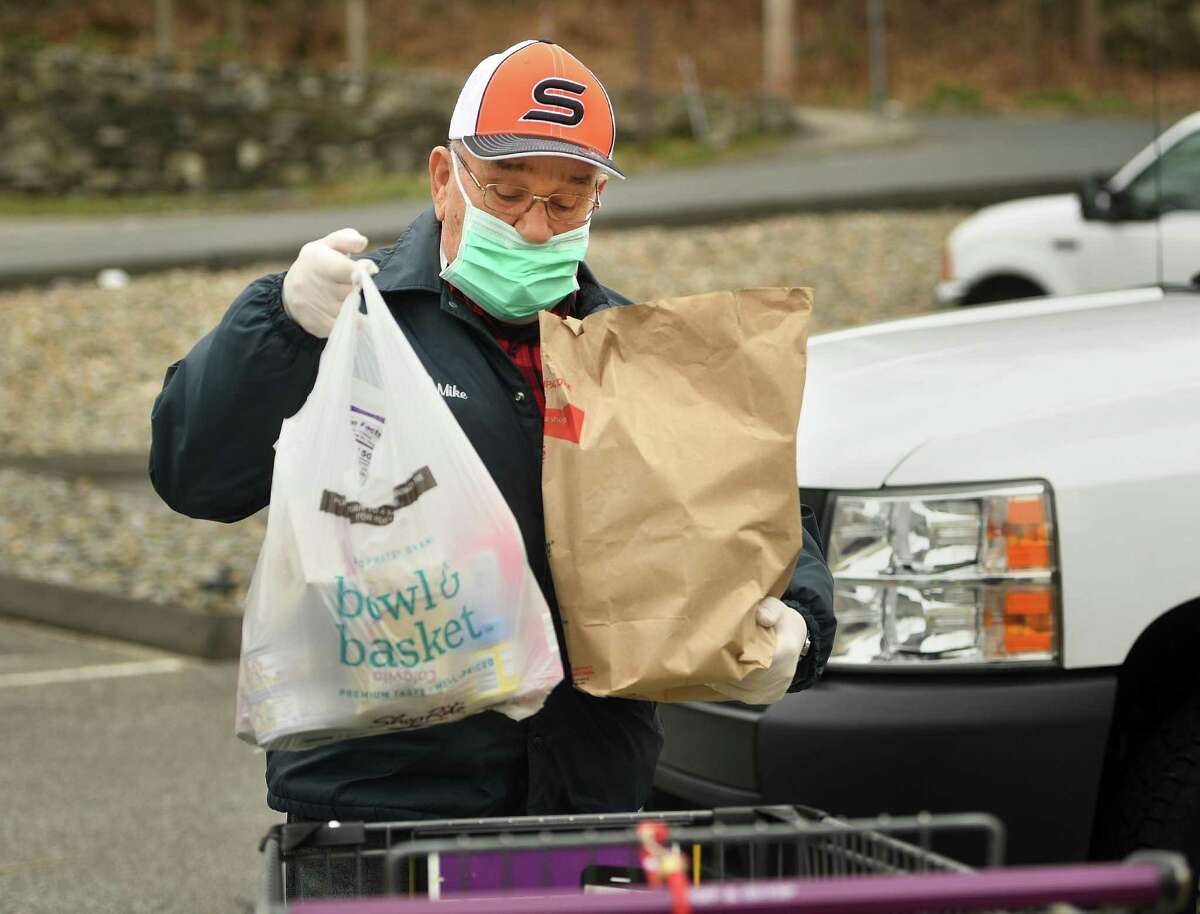 Mike Dokla, of Shelton, donates bags of food to the St. Vincent DePaul of the Valley Food Pantry at 237 Roosevelt Drive in Derby, Conn. on Sunday, April 5, 2020. The pantry has been accepting new clients in the wake of the coronavirus pandemic.
