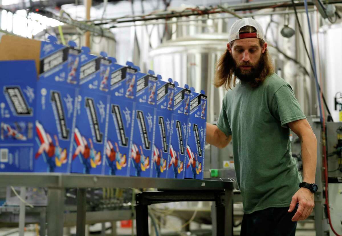 Employees prepare boxes to store Southern Star Brewing’s Bombshell Blonde, Friday, April 3, 2020, in Conroe.