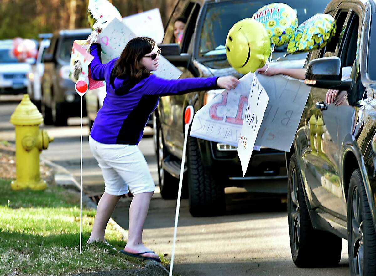 Elizabeth Romanovsky, 15, is given a happy birthday sign and gallons during a surprise parade of cars slowly driving by her Orange home on Green Circle Road celebrating her 15th birthday April 06, 2020 in lieu of a party to comply with the social distancing protocol during the coronavirus pandemic.
