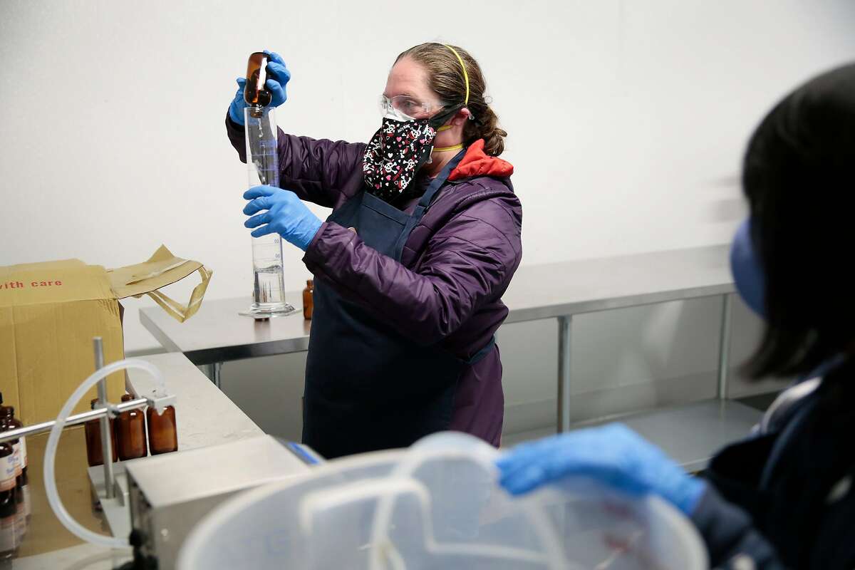 Cheriene Griffith, director of operations, left, and cannabis baker Dan Nguyen demo a dry run of hand sanitizer production at The Galley cannabis production facility in Santa Rosa, California, Tuesday, April 7, 2020. The company is responding to the COVID-19 pandemic by starting production of �Stop & Sanitize� hand sanitizer spray in their new production facility. Ramin Rahimian/Special to The Chronicle