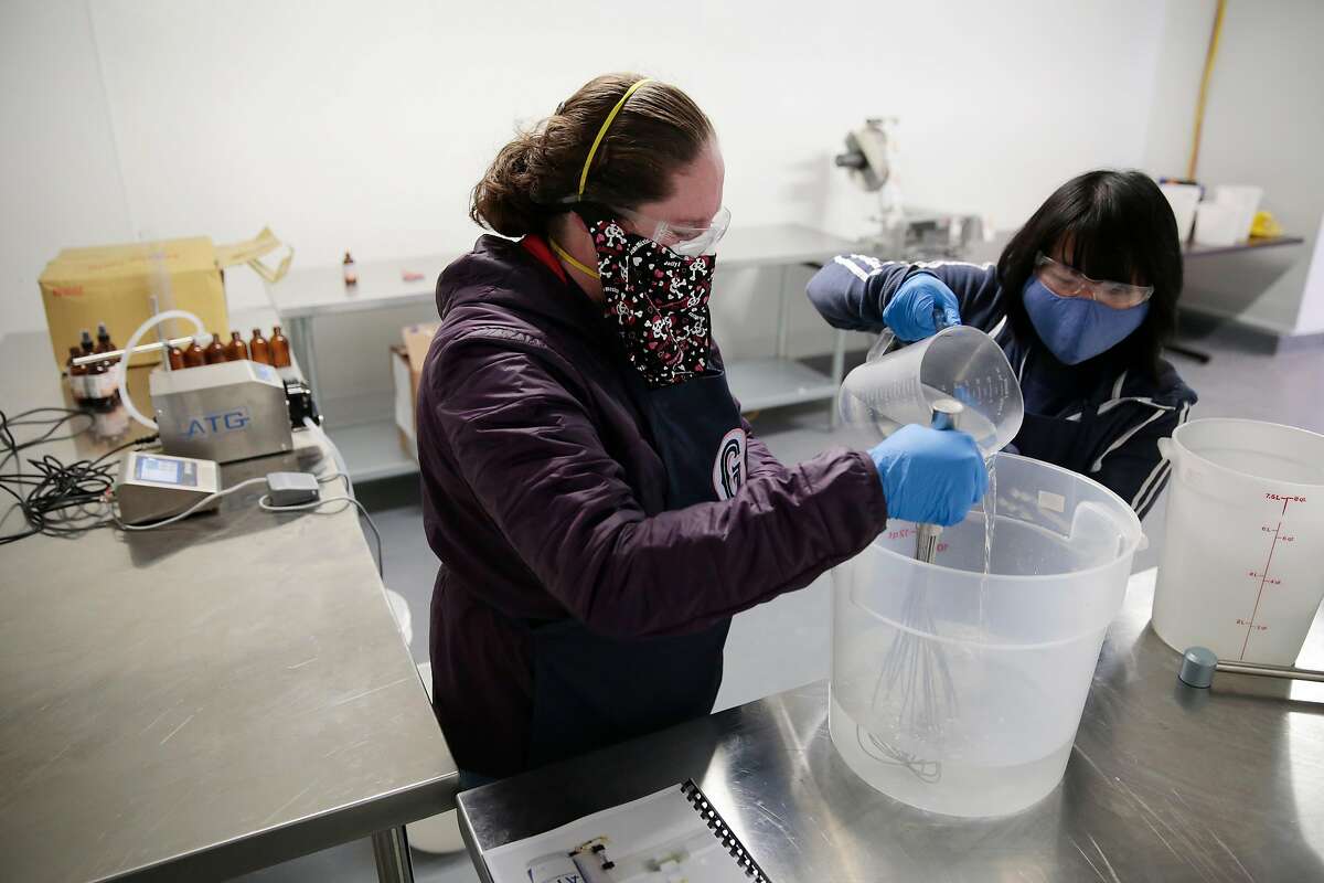 Cheriene Griffith, director of operations, left, and cannabis baker Dan Nguyen demo a dry run of hand sanitizer production at The Galley cannabis production facility in Santa Rosa, California, Tuesday, April 7, 2020. The company is responding to the COVID-19 pandemic by starting production of �Stop & Sanitize� hand sanitizer spray in their new production facility. Ramin Rahimian/Special to The Chronicle