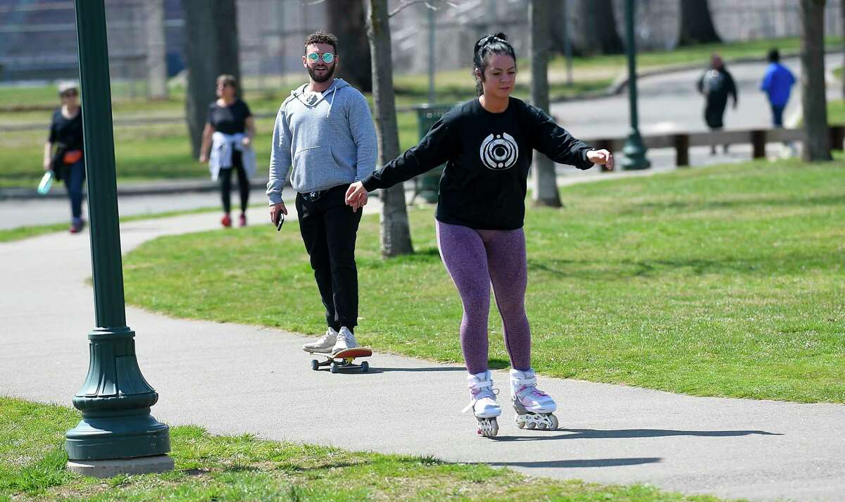 From left, Jacob Kaplan and his co-worker/roommate Danielle DeNitto, both of Stamford skateboard and roller blade while enjoying the spring like weather at Scalzi Park on April7, 2020 in Stamford, Connecticut. Kaplan and DeNitto, were taking a lunch break from the jobs with inDeed, hoping to skate around at Scalzi's Skate Park, which they found was closed following concerns that Covid-19 could potentially be spread to skaters who may come in contact within the facility.