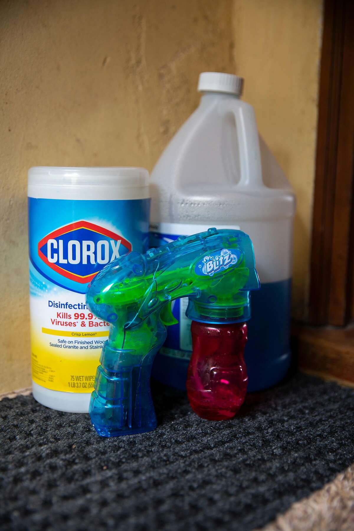 Izabel Arnold keeps disinfecting goods with a bubble toy gun for her son on home on Saturday, March 28, 2020, in San Francisco, Calif.