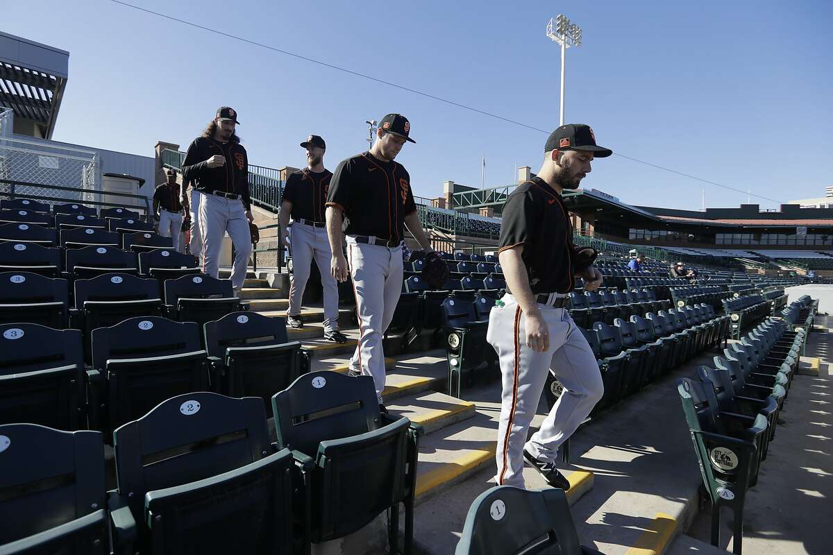 San Francisco Giants' Sam Moll, front, leads a group of players to the field during spring training baseball practice, Friday, Feb. 14, 2020, in Scottsdale, Ariz. (AP Photo/Darron Cummings)