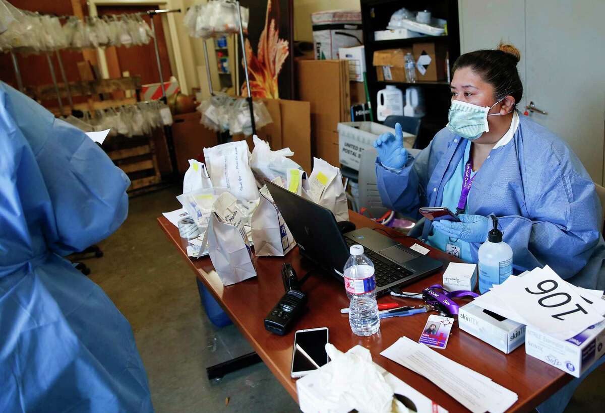 Pharmaceutical technician Norma Ollivares makes a call about a script at the San José Clinic in the Midtown neighborhood in Houston as they distribute 90-day prescriptions through a drive thru for their patients on Thursday, April 2, 2020.