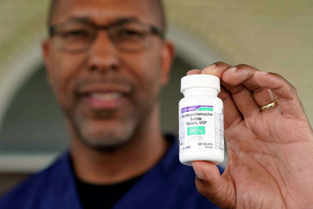 Dr. Robin Armstrong holds a bottle of hydroxychloroquine while standing outside The Resort at Texas City nursing home, where he is the medical director, on Tuesday, April 7, 2020, in Texas City, Texas.