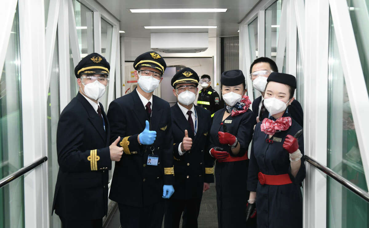 WUHAN, April 8, 2020. Crew members of flight MU2527 of China Eastern airlines pose for photos before takeoff at the Tianhe International Airport in Wuhan, central China's Hubei Province, April 8, 2020. Wuhan on Wednesday lifted outbound travel restrictions, after almost 11 weeks of lockdown to stem the spread of COVID-19. (Photo by Cheng Min/Xinhua via Getty) (Xinhua/Cheng Min via Getty Images)