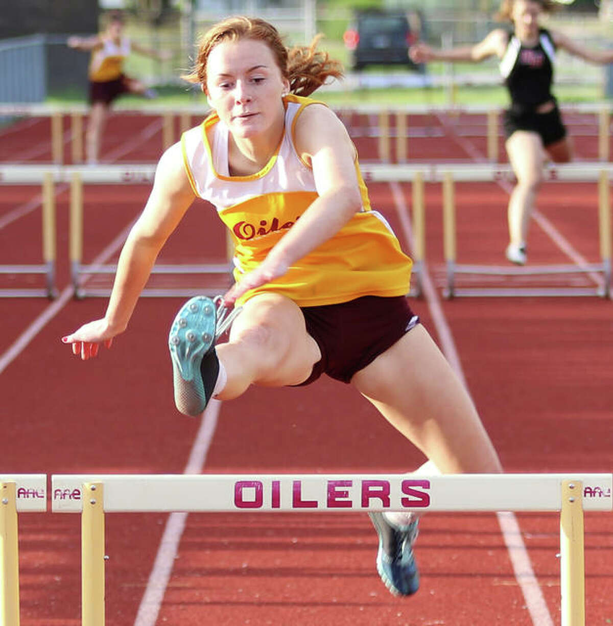 EA-WR’s LeighAnn Nottke clears a hurdle to complete a sweep of the two hurdles races as season at the Prairie State Conference Meet in Wood River. Nottke hopes to get back on the track for her senior season with the Oilers next month.