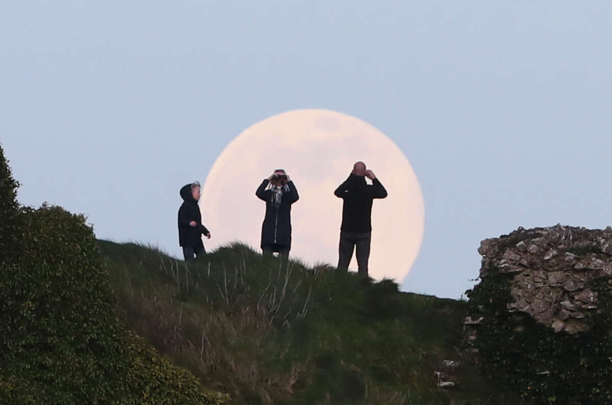 A pink supermoon rises over the Rock of Dunamase in County Laois in the Republic of Ireland. Despite its name, there is no actual colour change to the appearance of the lunar surface - it is a Northern Native American reference to an early-blooming wildflower, which starts to pop up in the US and Canada at the beginning of spring. (Photo by Niall Carson/PA Images via Getty Images)