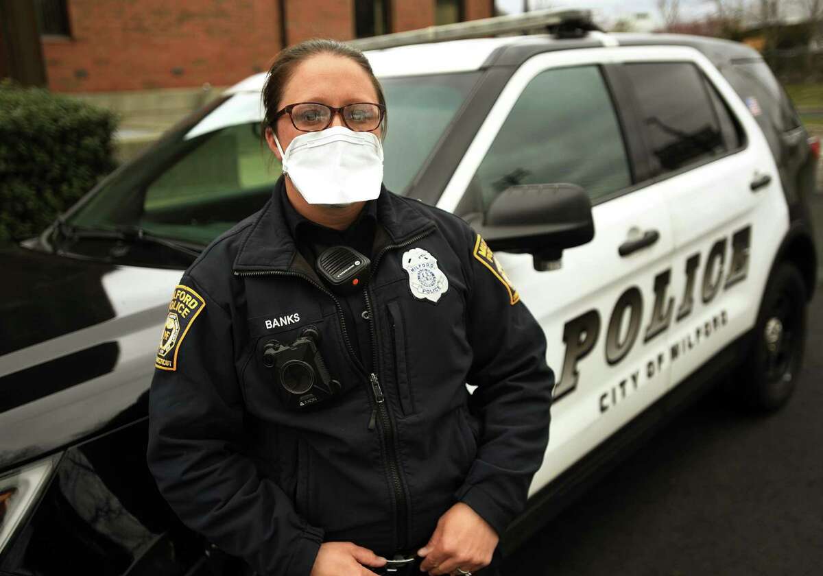 Milford police officer Karen Banks wears a protective mask that she and other officers are required to wear outside their vehicles in Milford, Conn. on Wednesday, April 8, 2020.