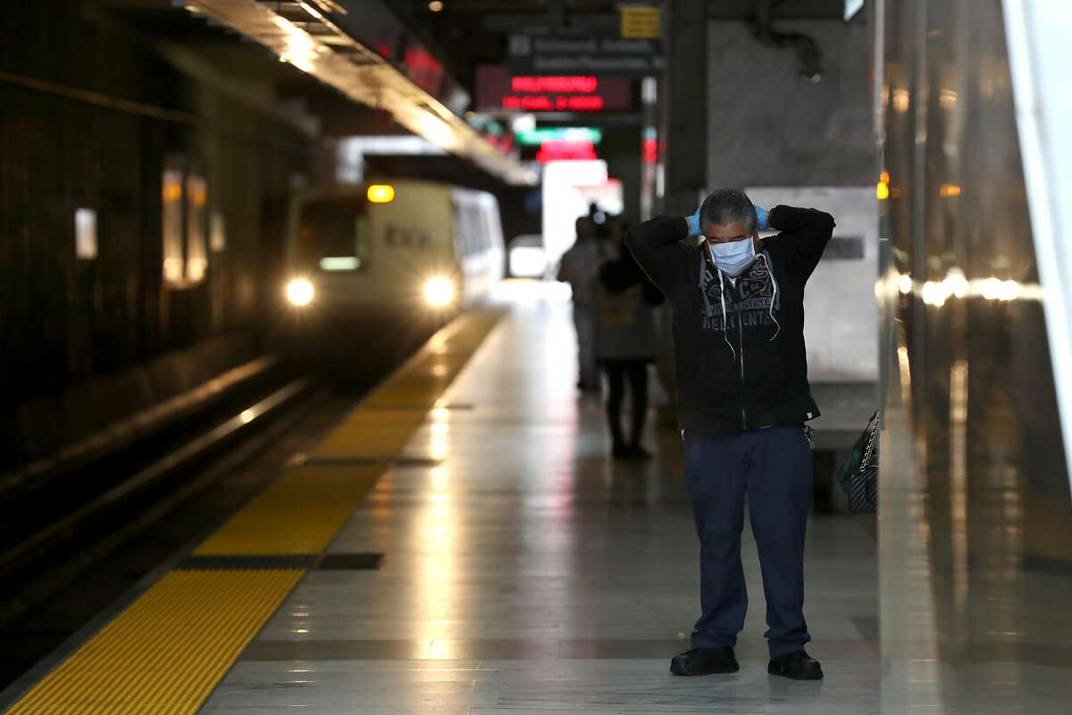 SAN FRANCISCO, CALIFORNIA - APRIL 08: A Bay Area Rapid Transit (BART) passenger adjusts his protective mask as a train pulls into the Balboa Park station on April 08, 2020 in San Francisco, California. BART announced that it is slashing daily service as ridership falls dramatically due to the coronavirus shelter in place order. Starting Wednesday, regular Monday through Friday service will be reduced to running trains every half hour between 5 am and 9 pm. (Photo by Justin Sullivan/Getty Images)