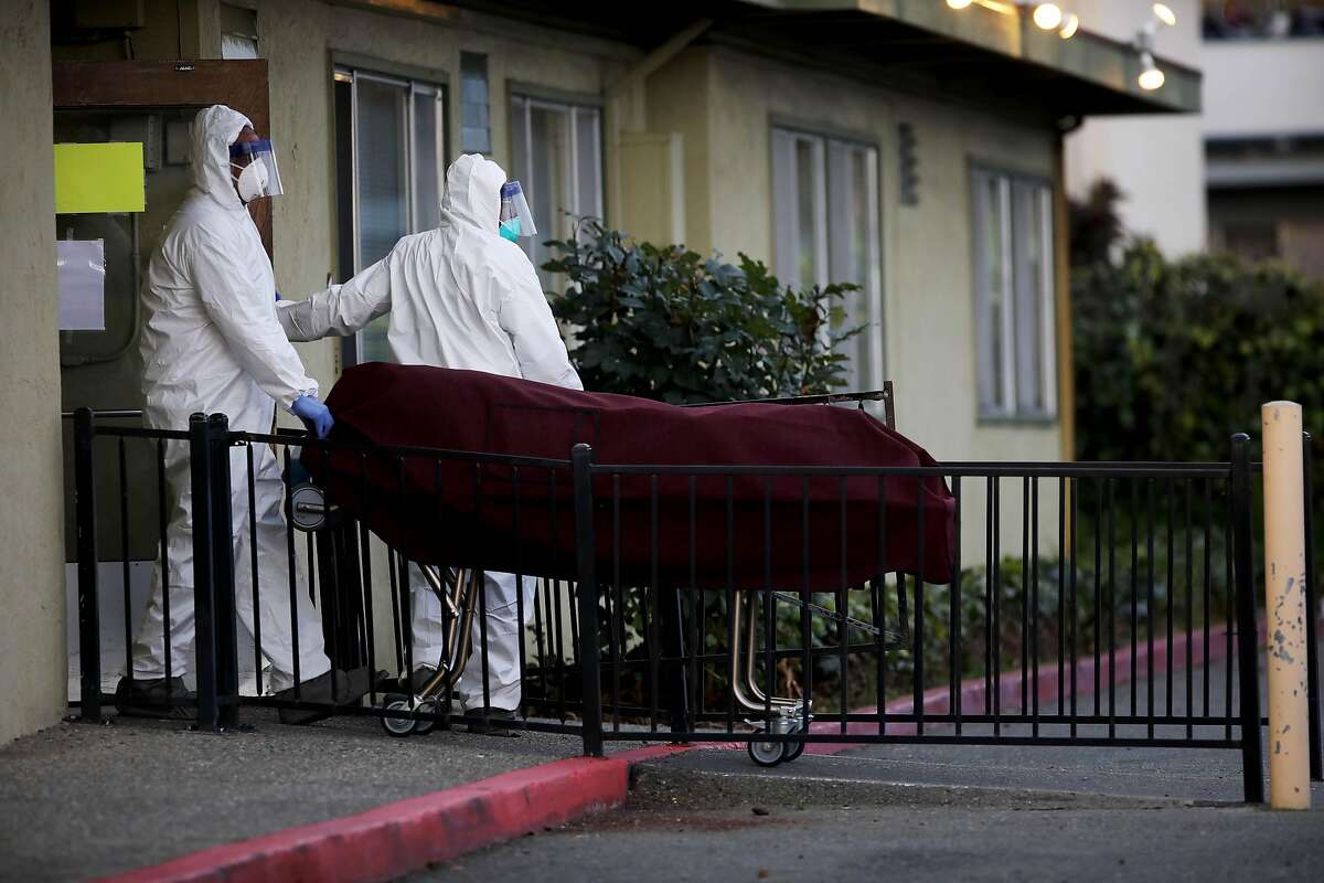 Men donning hazmat suits bring a body out of Gateway Care and Rehabilitation, located at 26660 Patrick Ave., on Wednesday, April 8, 2020, in Hayward, Calif. Six residents at the skilled nursing home in Hayward have died after being infected by the coronavirus in an outbreak at the facility that has infected 29 other residents and 24 staff members. Alameda County public health spokeswoman Neetu Balram confirmed the outbreak Wednesday afternoon.Officials are also monitoring an outbreak at East Bay Post-Acute Rehab in Castro Valley where seven people, including four staffers, have tested positive. Balram cautioned the number of infected persons at each facility could be updates and should be considered a "point-in-time" count. Health officials are tracing suspected and confirmed cases of COVID-19 at long-term care facilities throughout the county, Balram said.