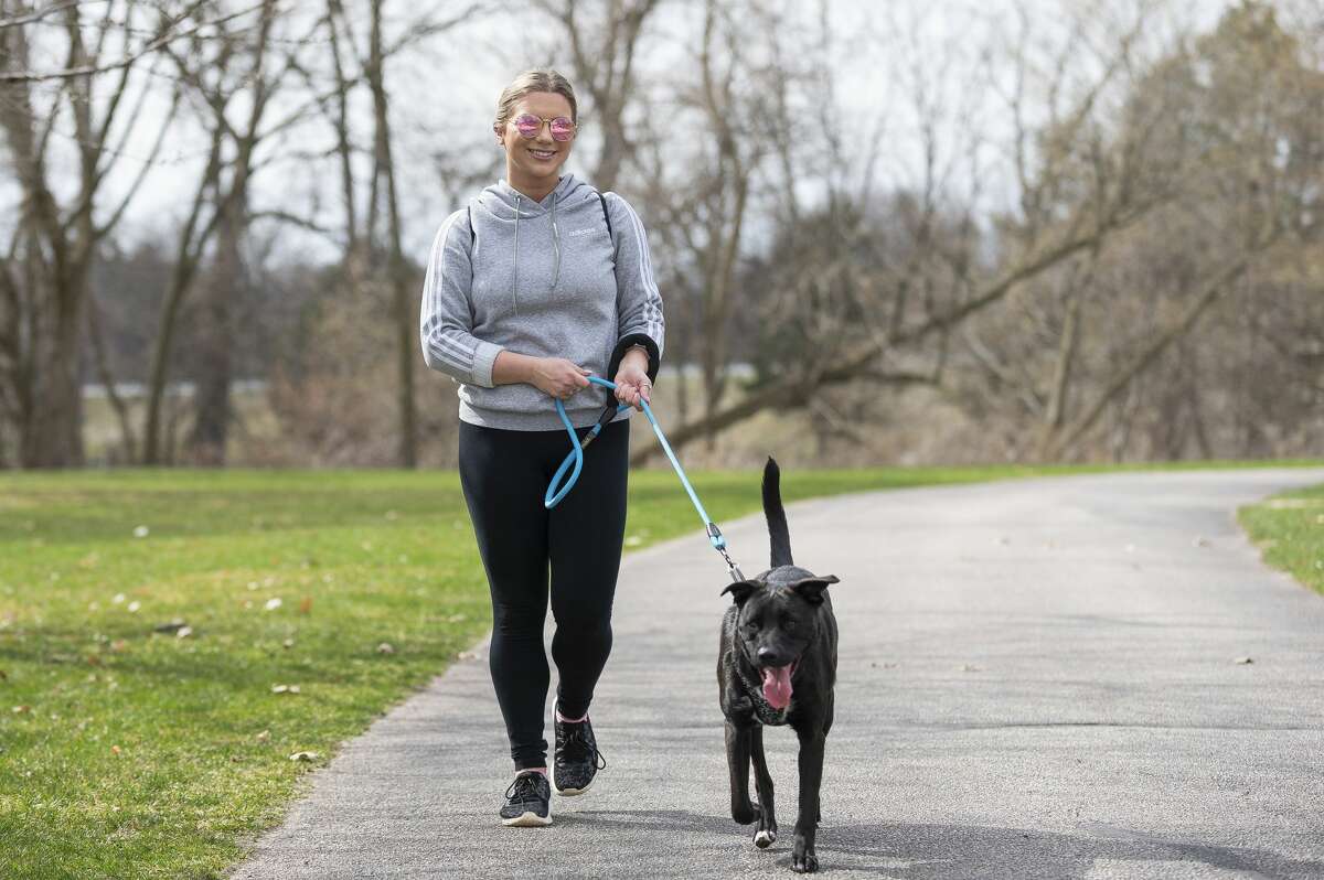 Lindsey Dice and her dog Gotti enjoy the weather on the Rail Trail Wednesday, April 8, 2020. (Adam Ferman/for the Daily News)