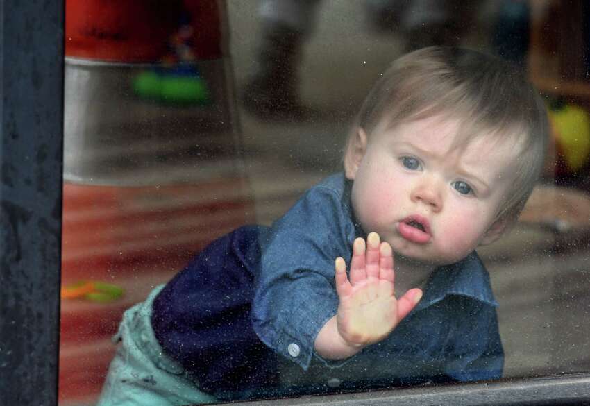 Easton Gillespie, 10 months, peers out of daycare window at the YMCA KidzLodge Early Learning Center on Thursday, April 9, 2020, in Clifton Park, N.Y. (Will Waldron/Times Union)