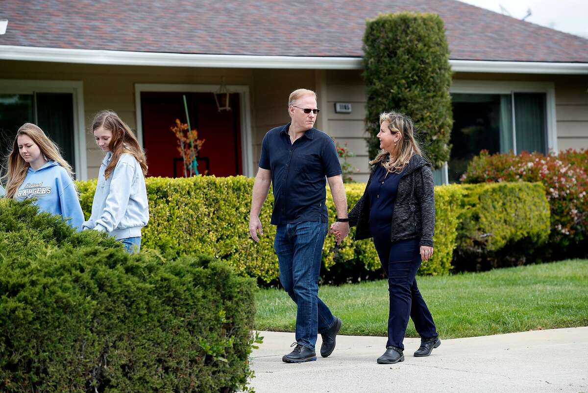 (Left-right) Daughters Sarah McKinney,18, Sabrina McKinney, 15, dad Rick McKinney, holds hands with Rosemary Pathy-McKinney, as they go for an afternoon walk in their neighborhood in San Jose,California on April 8, 2020. Rosemary Pathy-McKinney, is a San Jose schoolteacher who was on her way into brains surgery for a tumor at UCSF Parnassus on March 15 when the surgery was abruptly postponed because it was deemed "elective." The surgery ward was being prepared to only treat COVID patients who have still not materialized.