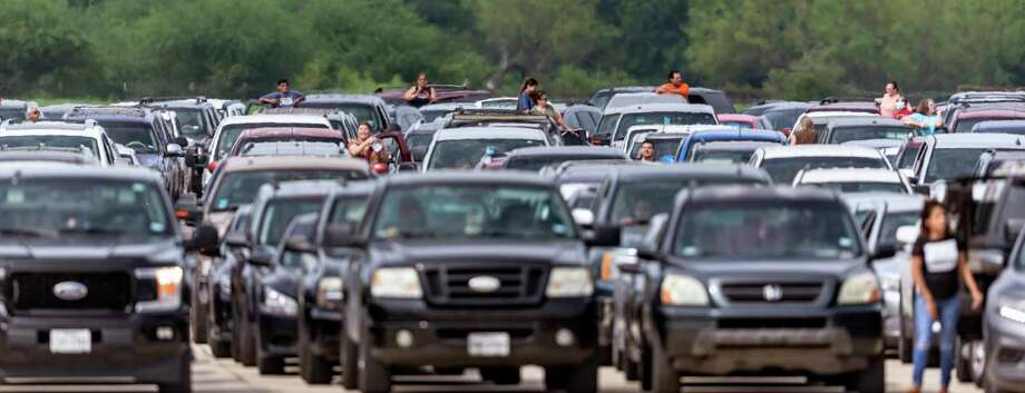 People wait at Traders Village for the San Antonio Food Bank to begin food distribution. Photo: William Luther, Staff / ©2020 San Antonio Express-News