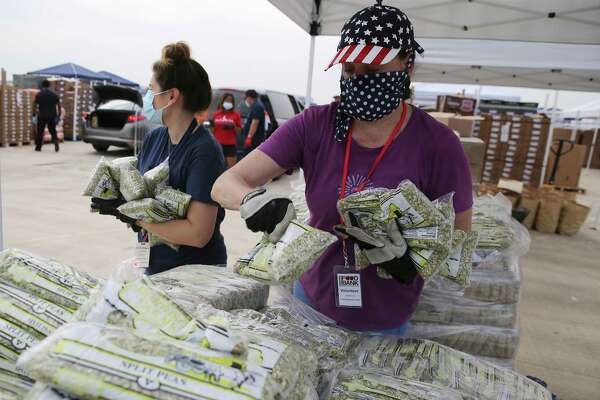 Helpers Jennifer Byrnes (right) and Alisa Alonzo gather bags of split pea to load into cars.