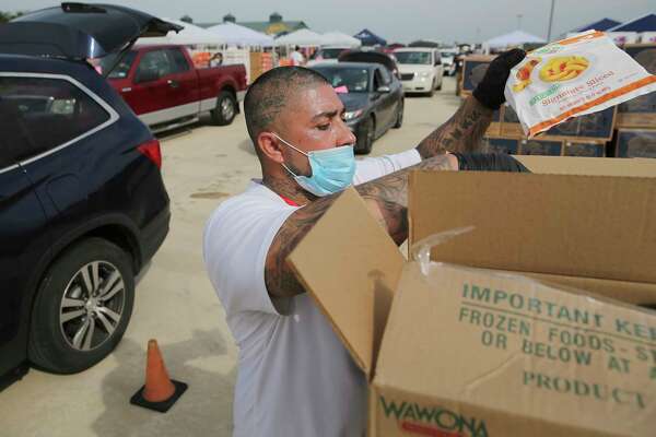 Anthony Gaitan picks up bags of peaches to load into a vehicle.
