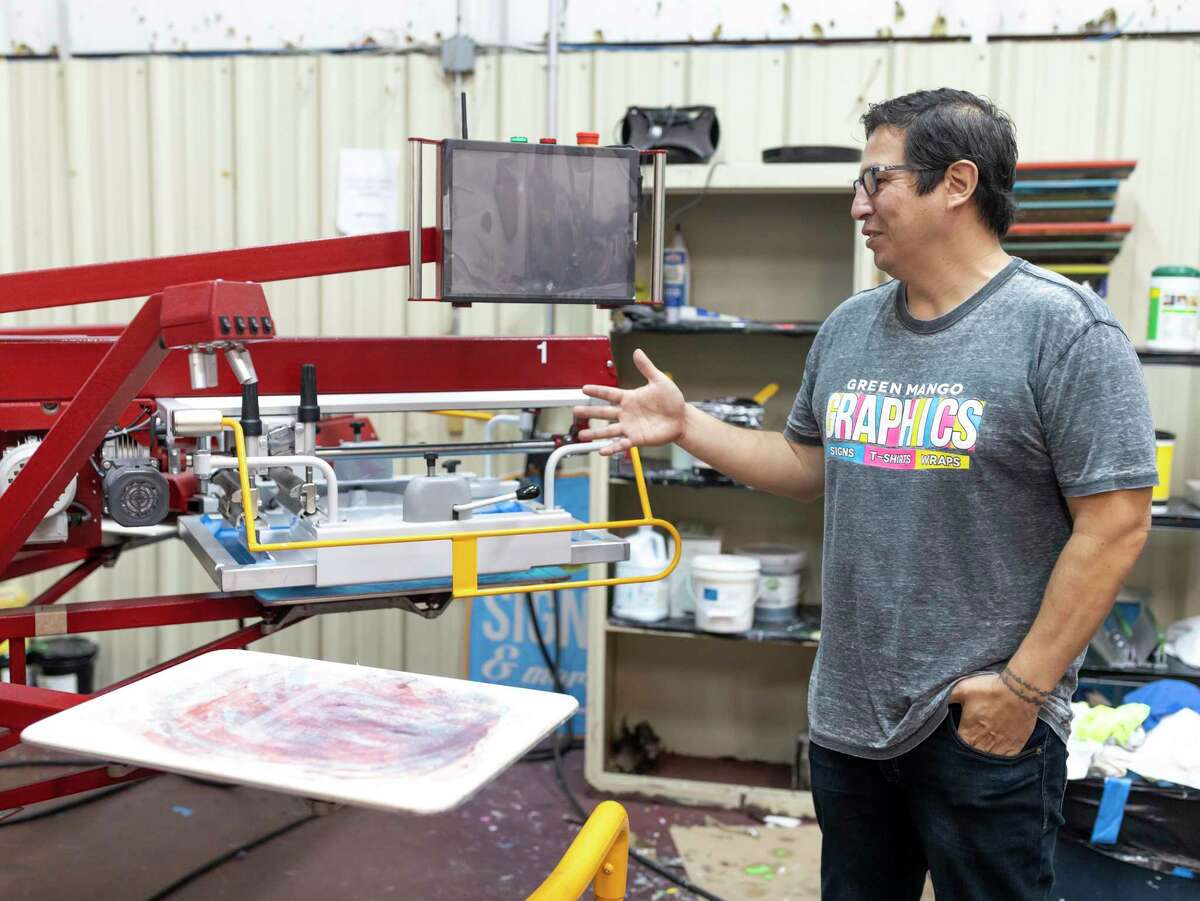 Rocky Castillo, owner of Green Mango Graphics in Conroe, explains the screen printing process in his shop, Thursday, April 9, 2020. Green Mango Graphics is working on an initiative called Montgomery County Strong where local businesses will partner with the company to create and sell shirts with their logo.