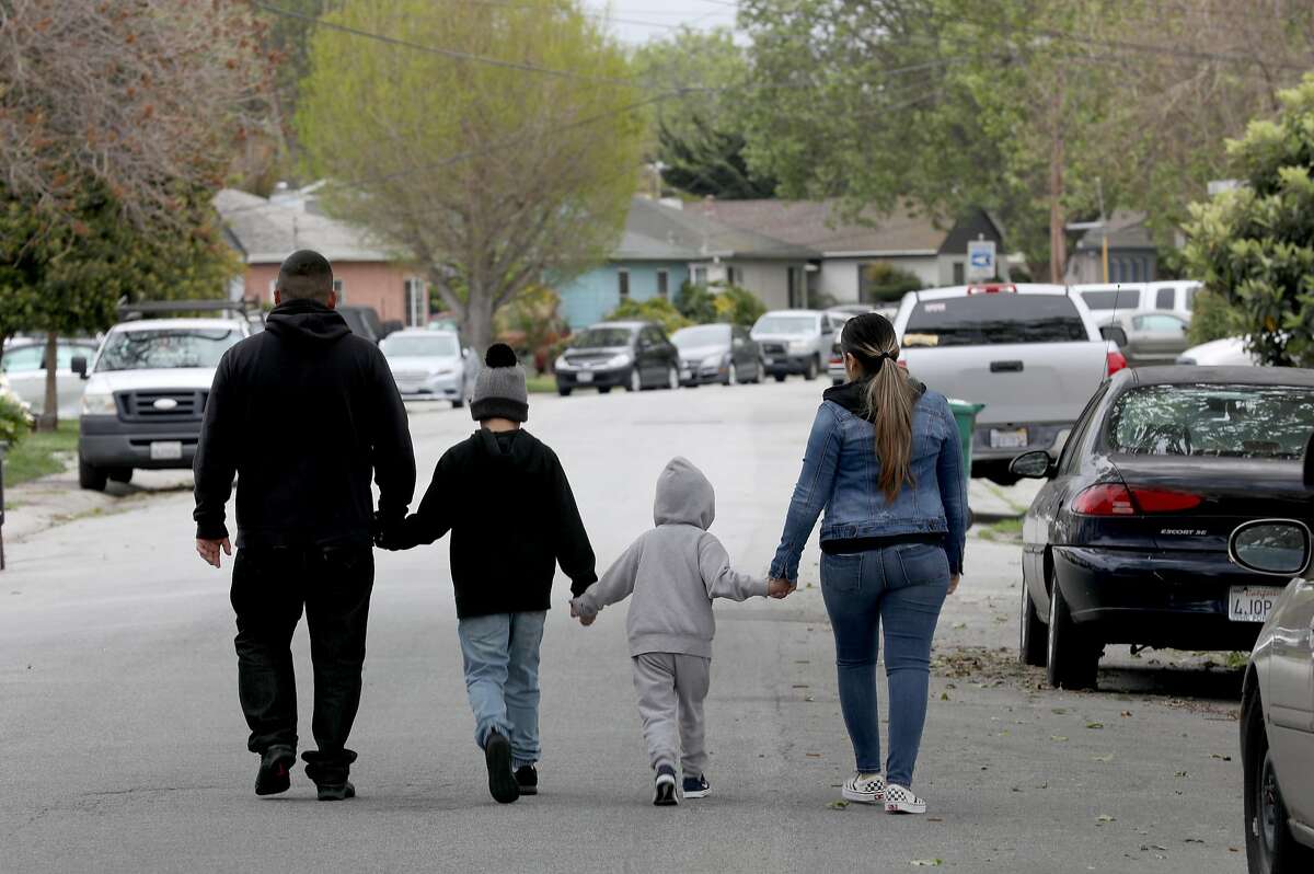 Christian (left) and his wife Monze (right) were laid off from restaurant jobs in mid-March and not qualified to receive unemployment because they are undocumented immigrants as they walk with their 9 and 4 year old sons on Thursday, April 9, 2020, in San Lorenzo, Calif.
